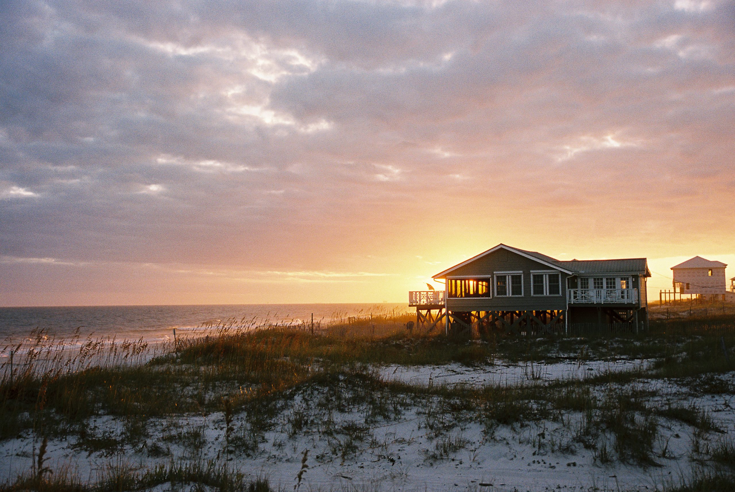 Beachfront Stilt Home at Sunset with Sand Dunes and Ocean View.jpg